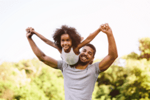 Celebramos a los papás: un papá feliz juega con su hija riendo en el Día del Padre